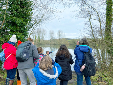 Group of families look for birds on lake