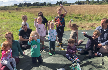 Children hold up their handmade dragonflies