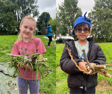 Two children show their handmade bug houses